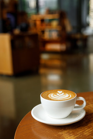 Cup of hot milk latte coffee on table by the window. Selective focus.の写真素材