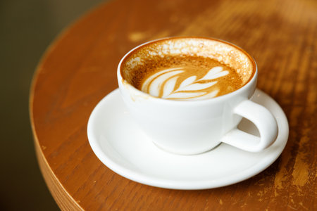 Cup of hot milk latte coffee on table by the window. Selective focus.の写真素材