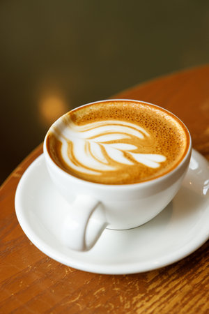 Cup of hot milk latte coffee on table by the window. Selective focus.の写真素材