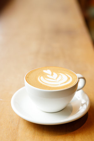 Cup of hot milk latte coffee on table by the window. Selective focus.の写真素材