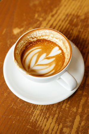 Cup of hot milk latte coffee on table by the window. Selective focus.の写真素材