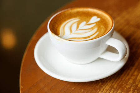Cup of hot milk latte coffee on table by the window. Selective focus.の写真素材