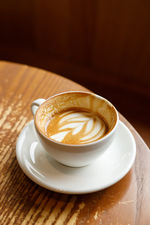 Cup of hot milk latte coffee on table by the window. Selective focus.の写真素材