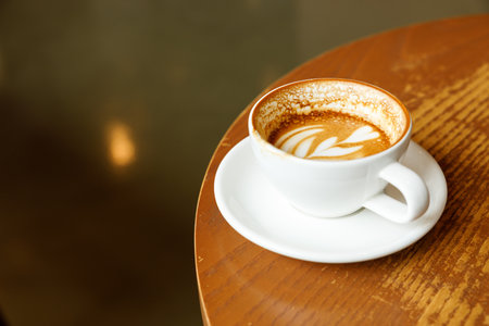Cup of hot milk latte coffee on table by the window. Selective focus.の写真素材