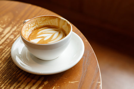 Cup of hot milk latte coffee on table by the window. Selective focus.の写真素材