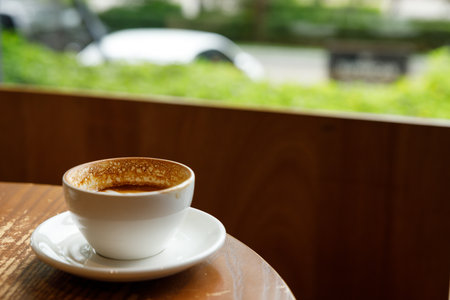 Empty cup of hot milk latte coffee on table by the window. Selective focus.の写真素材