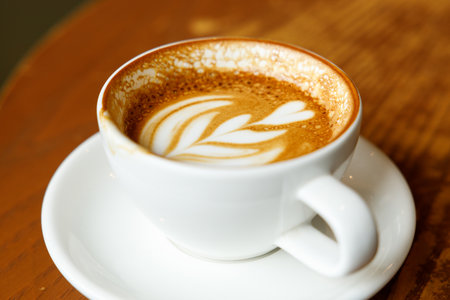 Cup of hot milk latte coffee on table by the window. Selective focus.の写真素材