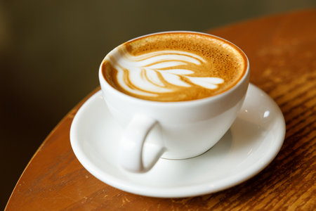 Cup of hot milk latte coffee on table by the window. Selective focus.の写真素材