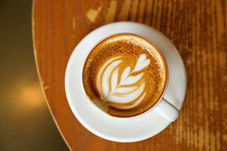 Cup of hot milk latte coffee on table by the window. Selective focus.の写真素材