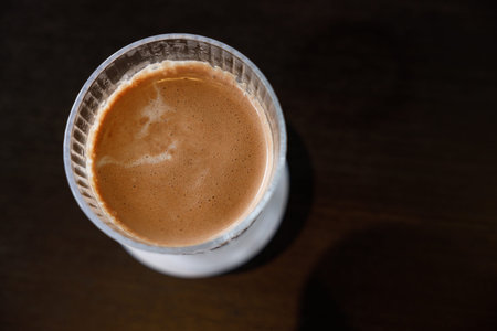 Glass of delicious cold milk chocolate on black wooden table background. Selective focus.