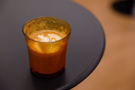 Cup of hot milk latte coffee on table. Selective focus.