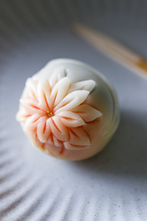 A piece of Japanese confectionery on off white ceramic plate on wooden table. Selective focus.の写真素材