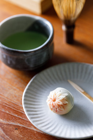 Cup of fresh matcha tea, green tea and Nerikiri, Japanese confectionery, on wooden table. Selective focusの写真素材