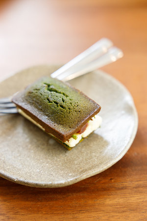 A piece of Cheese and Matcha and red bean paste financier, small French almond cake, on wooden table. Selective focus.の写真素材