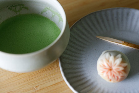 Cup of fresh matcha tea, green tea and Nerikiri, Japanese confectionery, on wooden table. Selective focusの写真素材