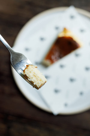 A small piece of cheese cake on a fork. Selective focus.