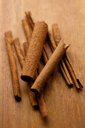 Cinnamon sticks dried tree bark spice on rustic wooden table background. Selective focus.