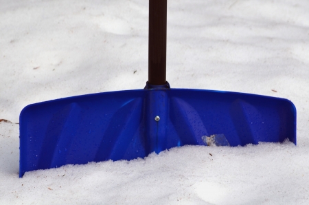 A blue snow shovel in the snowの写真素材