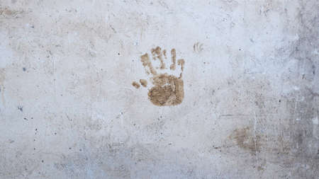Single hand print on outdoor old cement wall. Abstract grunge background texture. Copy Spaceの写真素材