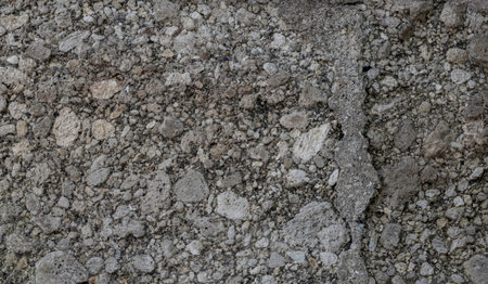 Close up view of weathered crumbling gray concrete wall texture