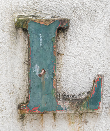 Dirty and decaying painted alphabet letter L on concrete wall. Copy space.の写真素材