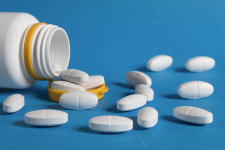 Many medical pills of different colors and shapes scattered, close-up. Pills in capsule form on the...