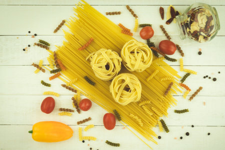 Raw spaghetti and pasta with space for text on a wooden background. Selection of mixed dried pasta on wooden backgroundの写真素材