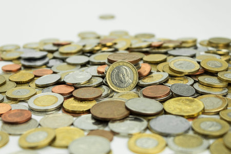 Pile of coins of different denominations on a white background. Money from different countries of...