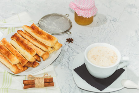 Delicious and sweet puff pastry sticks with cinnamon. Background with copy space