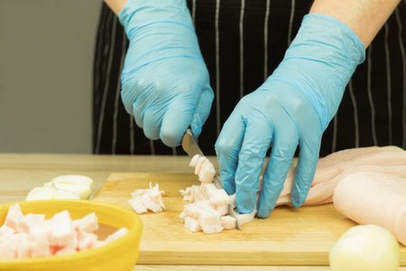 The hands of the cook are in flour and knead the dough. The cook kneads the dough for baking, makes splashes of flour. Faded colors and sun glareの写真素材