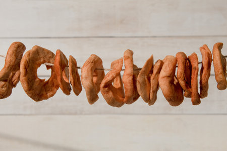 Slices of apples are dried on a rope. Background with copy space. Artistic food conceptの写真素材