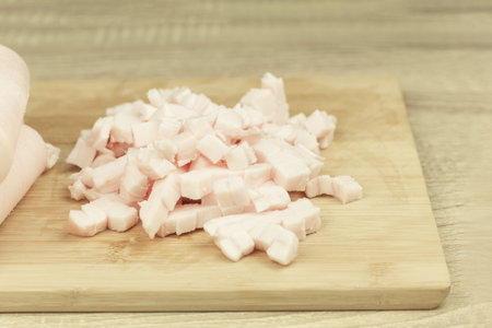 Fresh and raw lard finely chopped, meat on a cutting board. Salo ready for cooking. Salo, onion and spices for fryingの写真素材