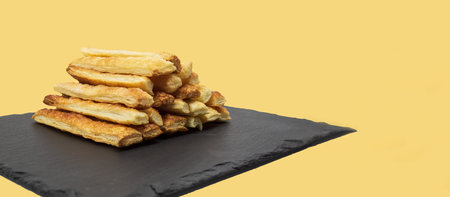 Delicious and sweet puff pastry sticks with cinnamon. Background with copy space