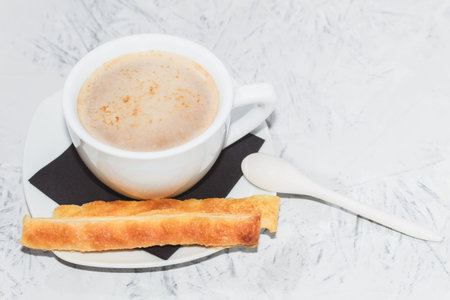 Fresh pastries and a white cup of coffee. Coffee and cookies. Background with copy space