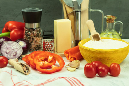 Ingredients on the table for making pizza. Pizza cooking process: dough, rolling pin, eggs, butter and wheat flour on a wooden table. Background with space for textの写真素材