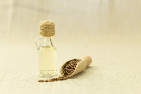 Flaxseeds and linseed oil. Linseed oil with kitchen utensils on an old wooden table. Copy space.の写真素材