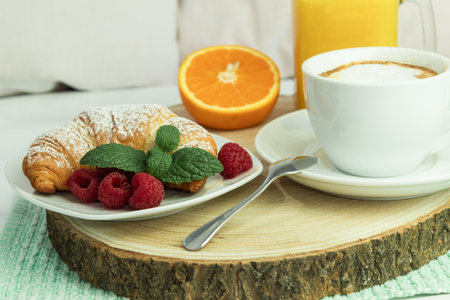 Fresh croissant and coffee on a wooden rustic background. Breakfast, a cup of coffee and fresh croissants, with fruitsの写真素材