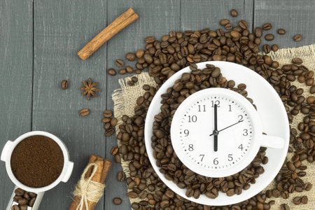 Alarm clock in a cup of coffee. Photo creative. Confluence Cup of fresh espresso with clock sign, top view. Space for textの写真素材