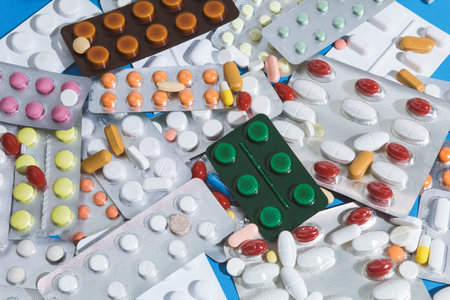 A large pile of pills in bundles scattered on the table. A mound of multi-colored tablets and...