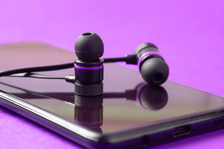 Mobile headphones on a mobile phone, close-up. Copy space