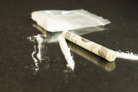 White powder is scattered on the table. White powder is scattered on the glass table next to the...