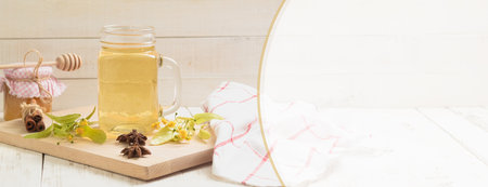 Lime tea in a glass cup. Medicinal linden tea, wooden background. Banner. Copy spaceの写真素材