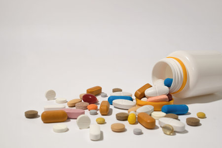 Many pills spilled from the plastic container. The concept of medicine, healthcare. Copy space. Text