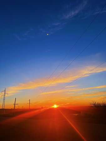 Sunset in the evening sky, silhouette of a power transmission lineの写真素材