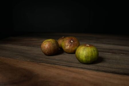 old lemon on wooden table in black background.の写真素材