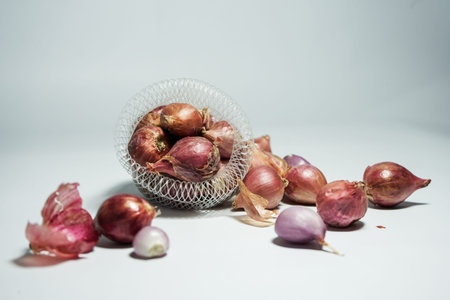 red garlic in net basket with white background.