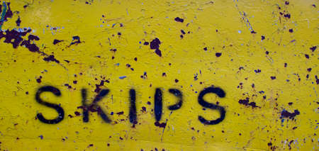 The word skips stencilled onto rusting yellow metal with copy spaceの写真素材