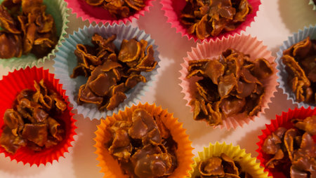 Full frame image of chocolate crispy cakes in coloured paper cases