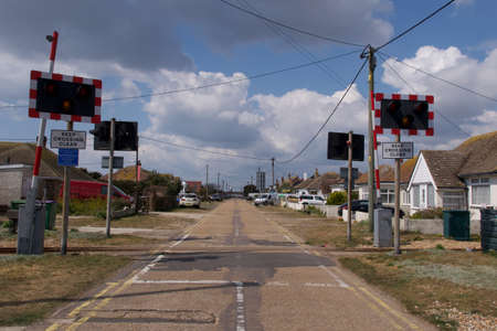15 May 2021 - Kent, UK: Level railway crossing across suburban roadのeditorial素材