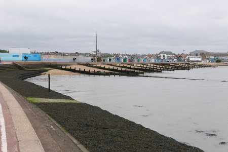 30 August 2021 - Essex, UK: Image of coast with breakwaters and beach huts